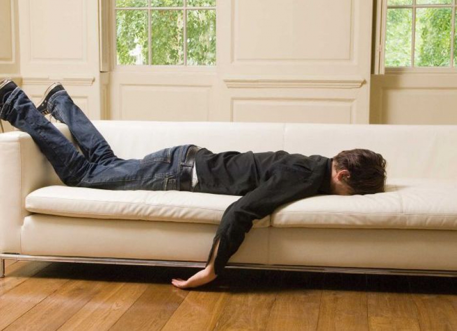 Соответствовать устал. Лежит на диване. Человек лежит на диване.