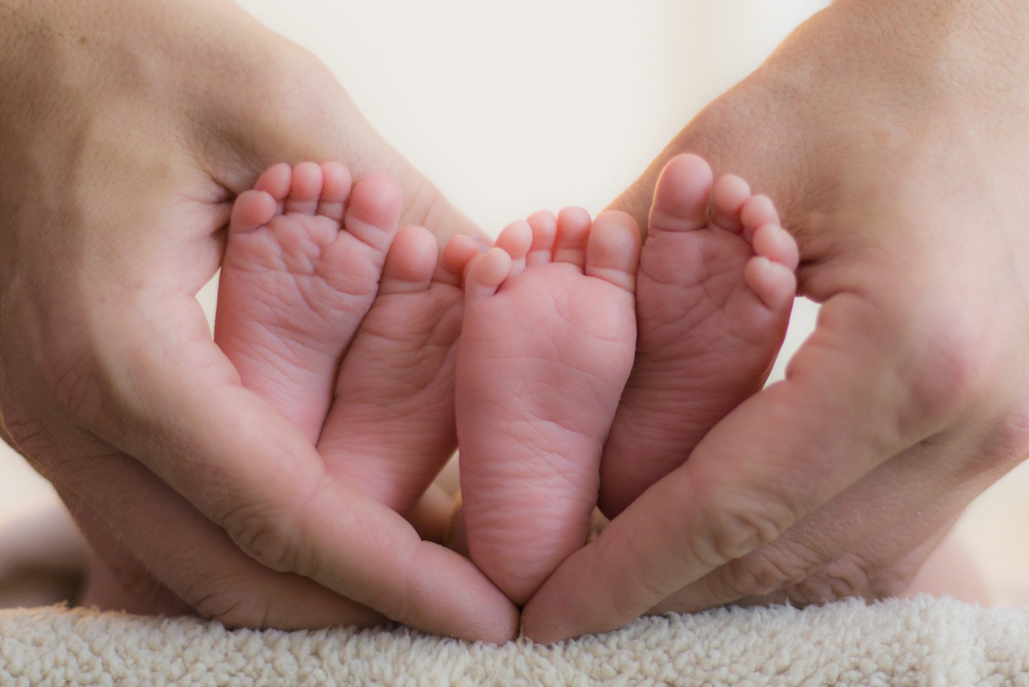 В июле 2015 родилось. Пяточки двойняшек. Ножки новорожденных близнецов. Ладонь младенца. Ножки двойняшек новорожденных.